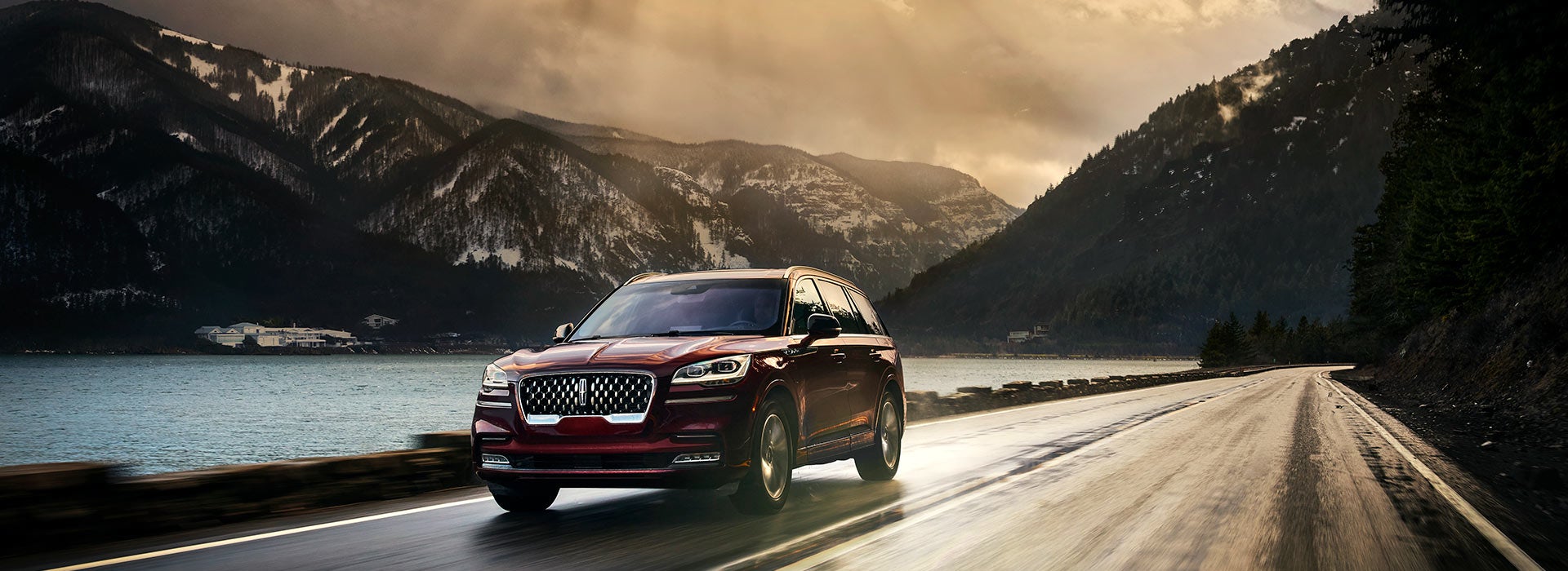 A 2021 Lincoln Aviator Grand touring is shown being driven in a river valley.