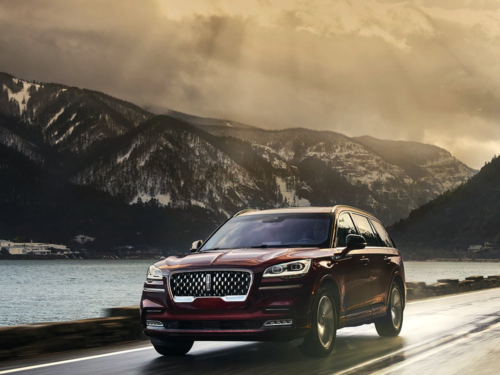 A 2021 Lincoln Aviator Grand touring is shown being driven in a river valley.