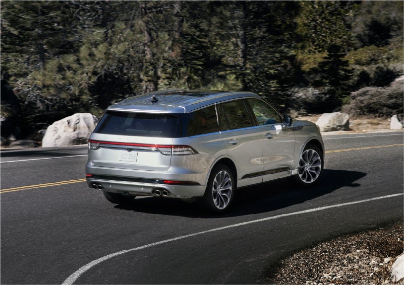 A 2023 Lincoln Aviator® Grand Touring model is shown being driven on a tight turn of a mountain road | Pines Lincoln in Pembroke Pines FL