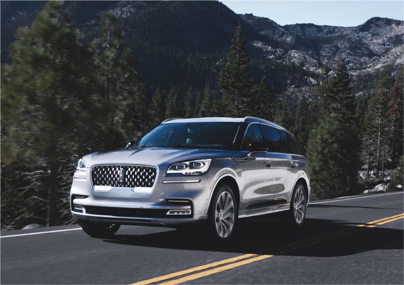 A 2023 Lincoln Aviator® Grand Touring SUV being driven on a winding road to demonstrate the capabilities of all-wheel drive | Pines Lincoln in Pembroke Pines FL