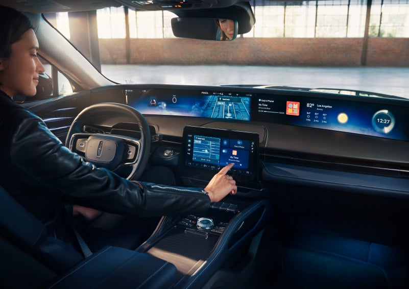 The driver of a 2024 Lincoln Nautilus® SUV interacts with the center touchscreen. | Pines Lincoln in Pembroke Pines FL